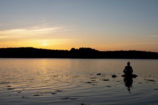 Meditation by a lake symbolizing the art of letting go and inner peace.